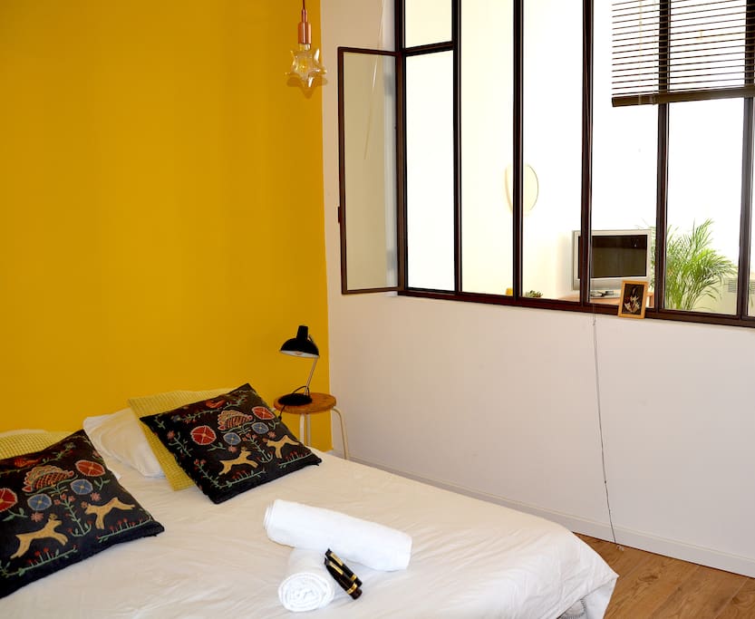 chambre pour 2 personnes avec placard, séparée par une verrière et des stores vénitiens