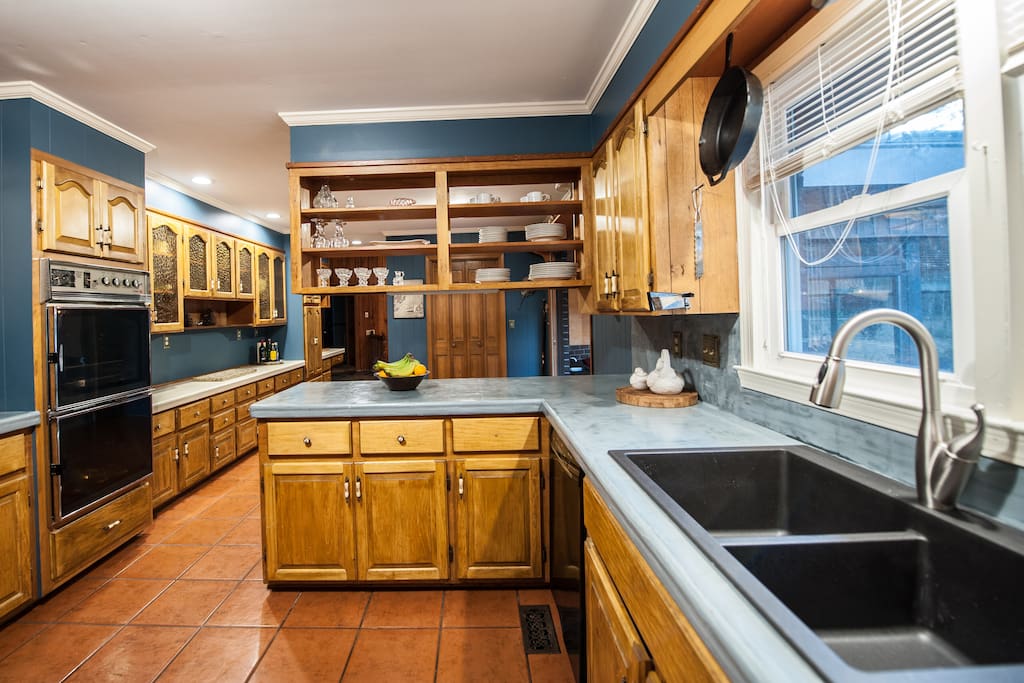 large kitchen featuring electric stove, large refrigerator, dishwasher, and double oven.