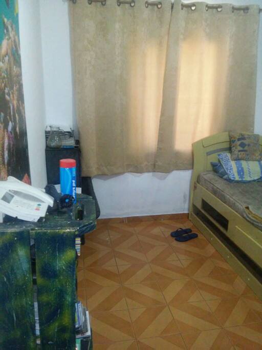 Quarto espaçoso, cama, guarda roupa, ferro de passar e vista para rua.