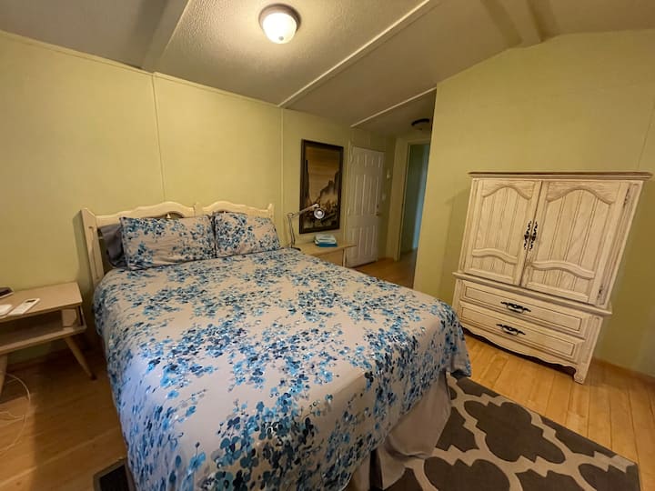 The master bedroom features a super comfy bed, vintage armoire and large closet.