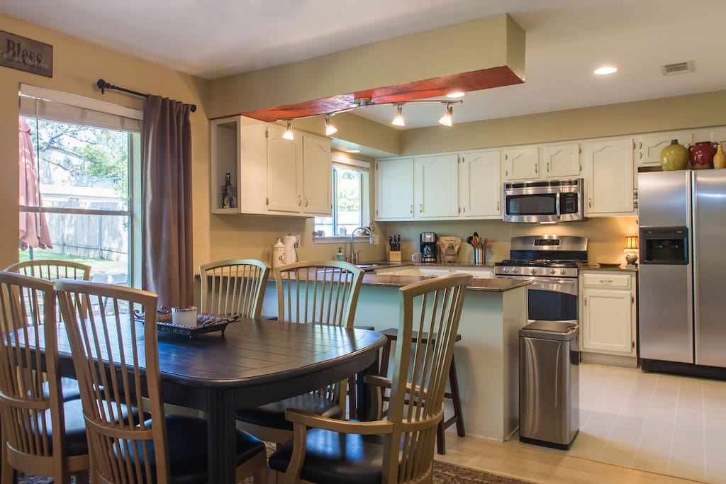Open concept kitchen and dining with seating for 9 people between the table and bar top. Extra table leaflets also available to extend table 3 feet if needed. Kitchen is fully stocked to cook and serve even a nice holiday meal.
