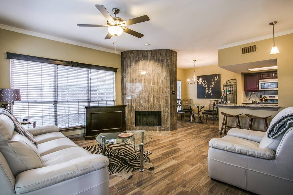 A 42" inch TV (Dish Network) is hidden inside the cabinet to the left of wood-burning fireplace, open floorplan, yet cozy setting, with a Texas feel