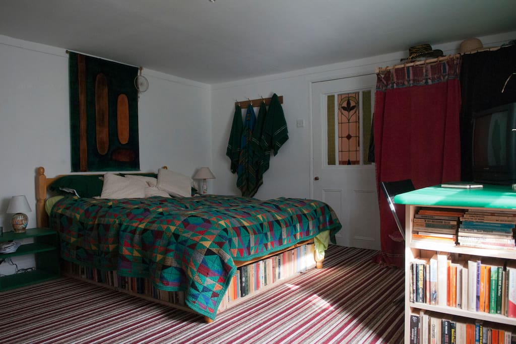 Bed is surrounded by books.