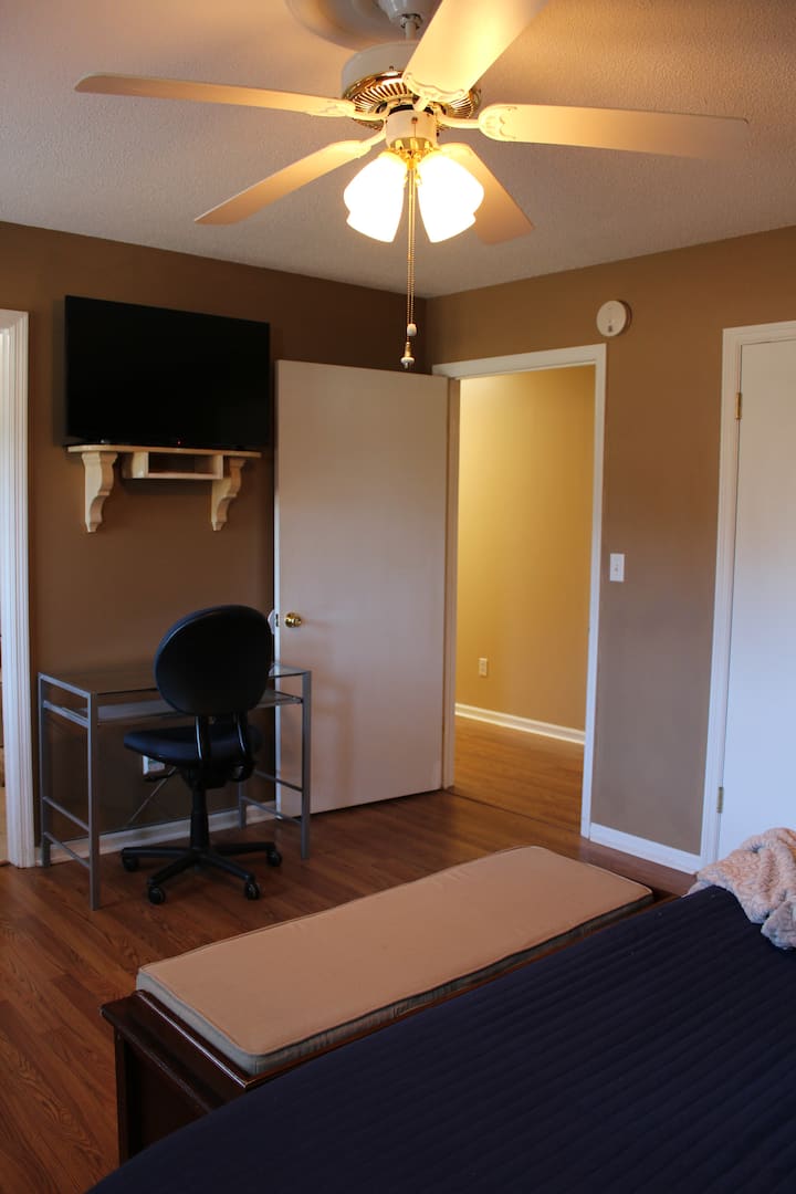 Телевизор монтиран на ѕид и погодно биро во мајсторот.