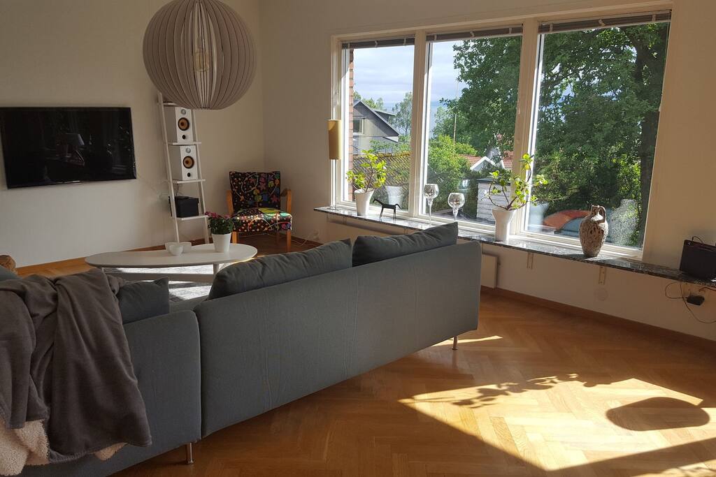 Vardagsrummet med stor hörnsoffa, 3×3 sits, fåtölj, TV.