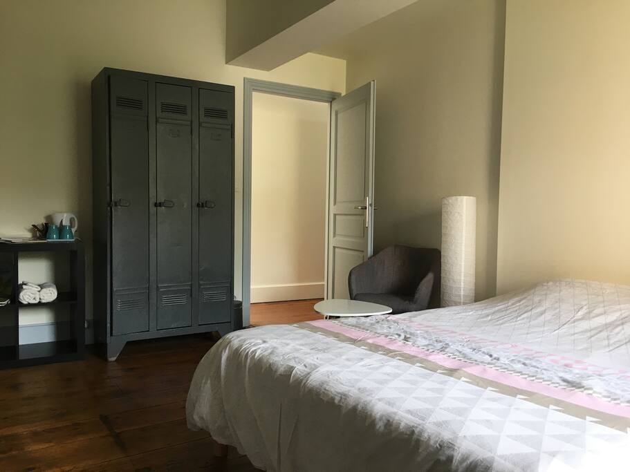 La chambre du 1er étage. Spacieuse (16m2), chaleureuse et volumineuse. Vous y trouverez un petit coin lecture, une penderie, les serviettes de bain, ainsi qu'une bouilloire avec de quoi se préparer une boisson chaude.