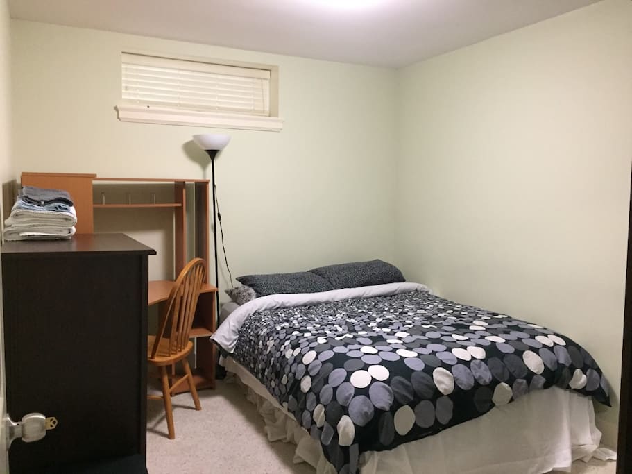 Queen bed, closet, dresser, desk, chair, ceiling and floor lights in private room