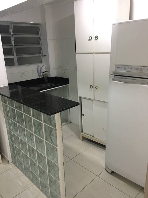 Cozinha com Geladeia, cooktop e balcão.