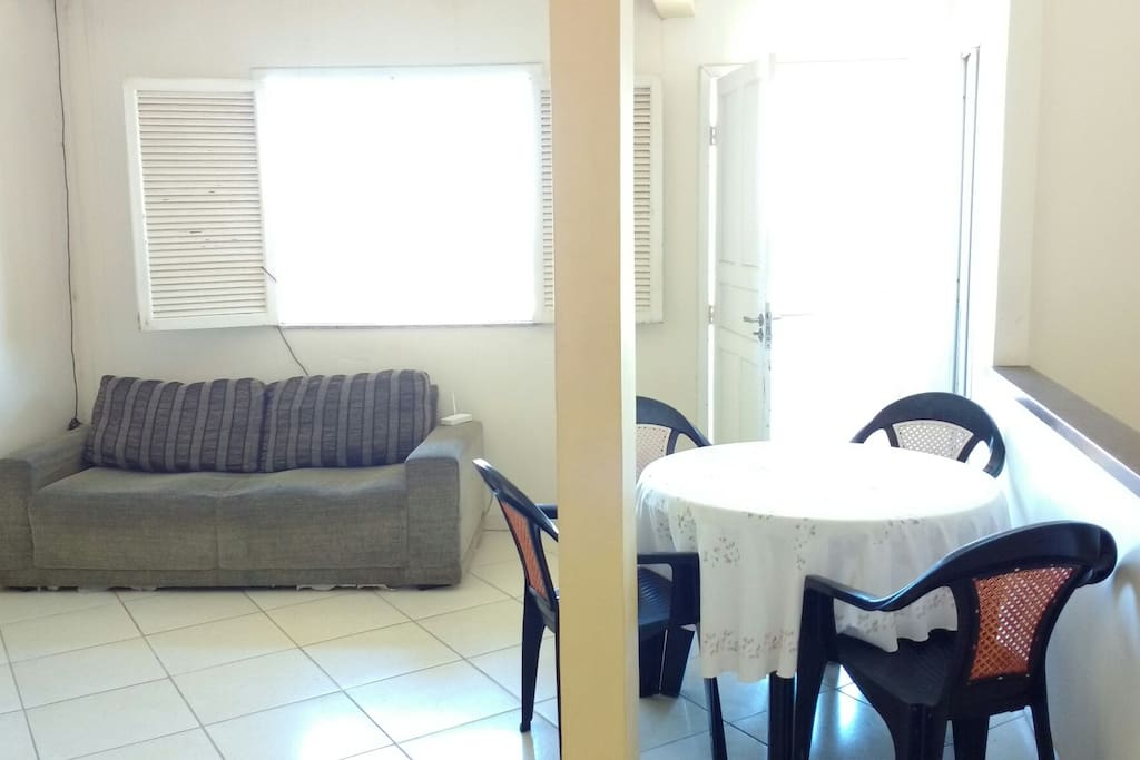 Sala com sofá, rack e mesa com 4 cadeiras