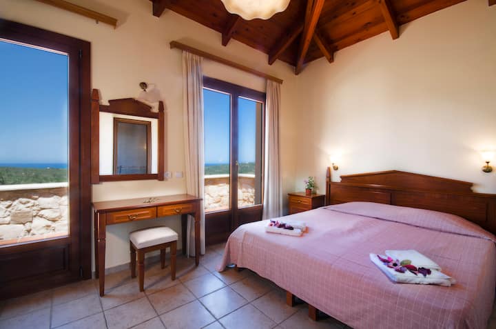 Primer dormitorio con una cama tamaño súper king