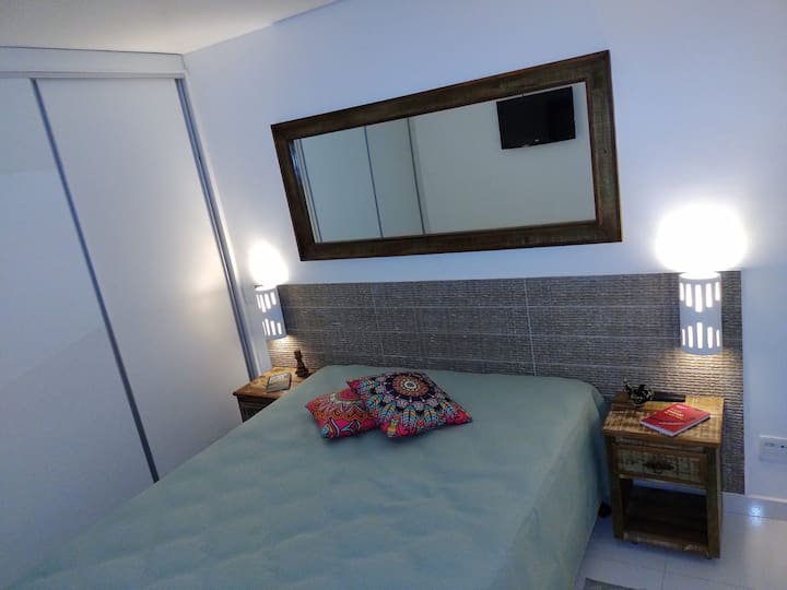 Spavaća soba s bračnim krevetom i prostorom s pogledom na more.