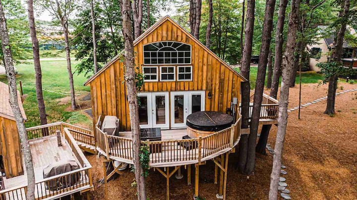 An aerial view of a patio in a Maine treehouse rental with a hot tub and grill
