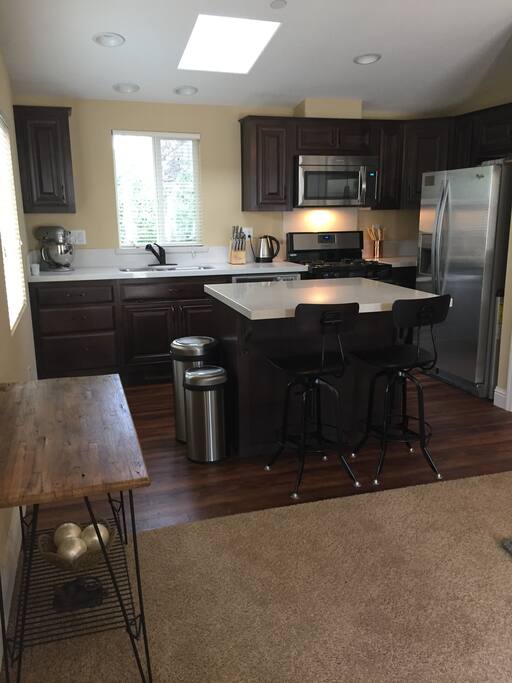 Kitchen, stove, refrigerator, microwave, and island table.