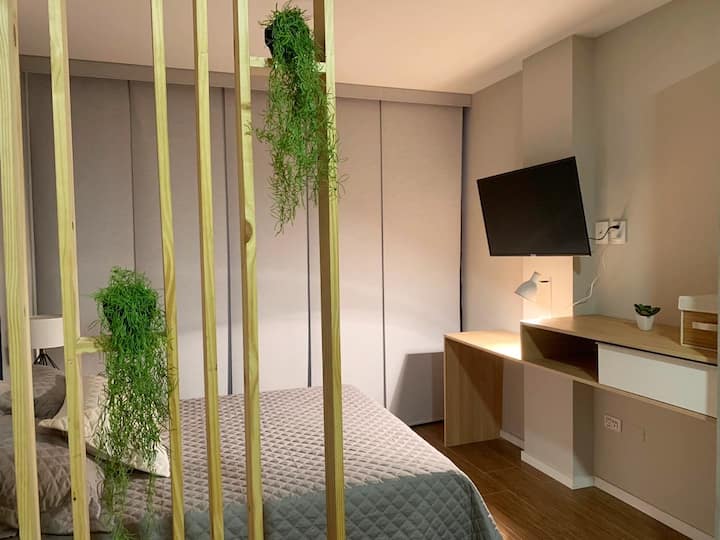 Chumba cha kulala kilicho na televisheni, kiyoyozi, mapazia meusi na mtaro mdogo wa nje