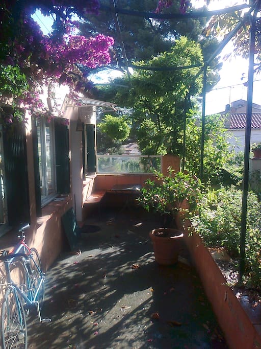 Coin repas sous la glycine entre le jardin et l'appartement.