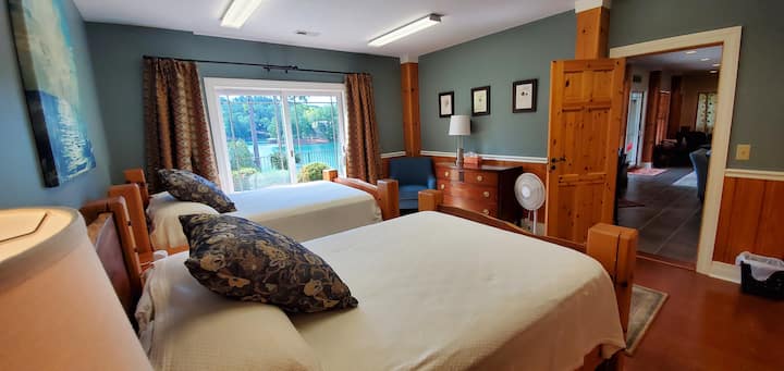 Двокреветна соба на пониско ниво со лизгачки врати до езеро и поплочен двор