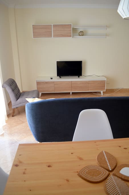 Spacious living room with TV and a table for 4