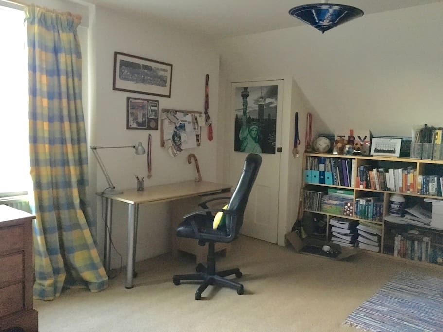 The desk and bookcase , on the right of the window