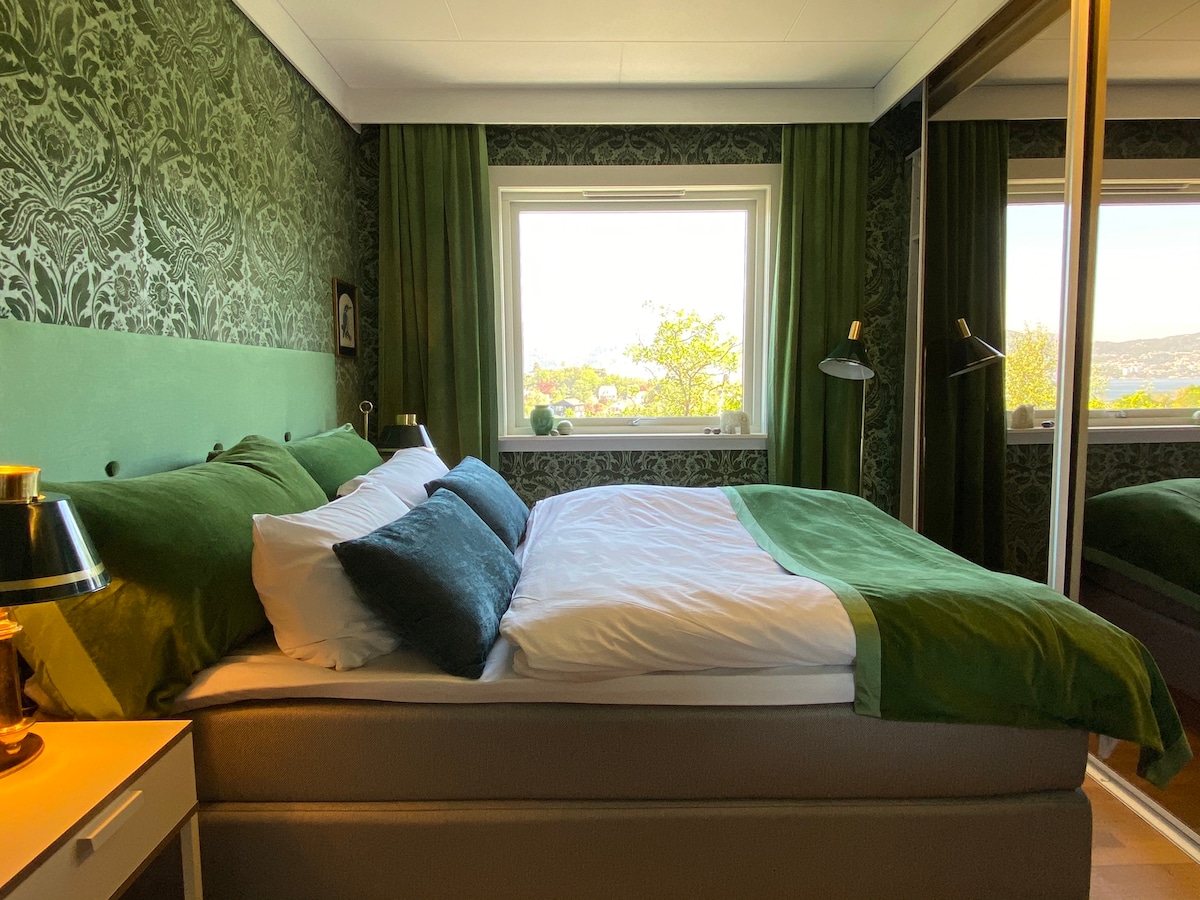 Krásna zelená spálňa s veľkým zrkadlovým šatníkom.