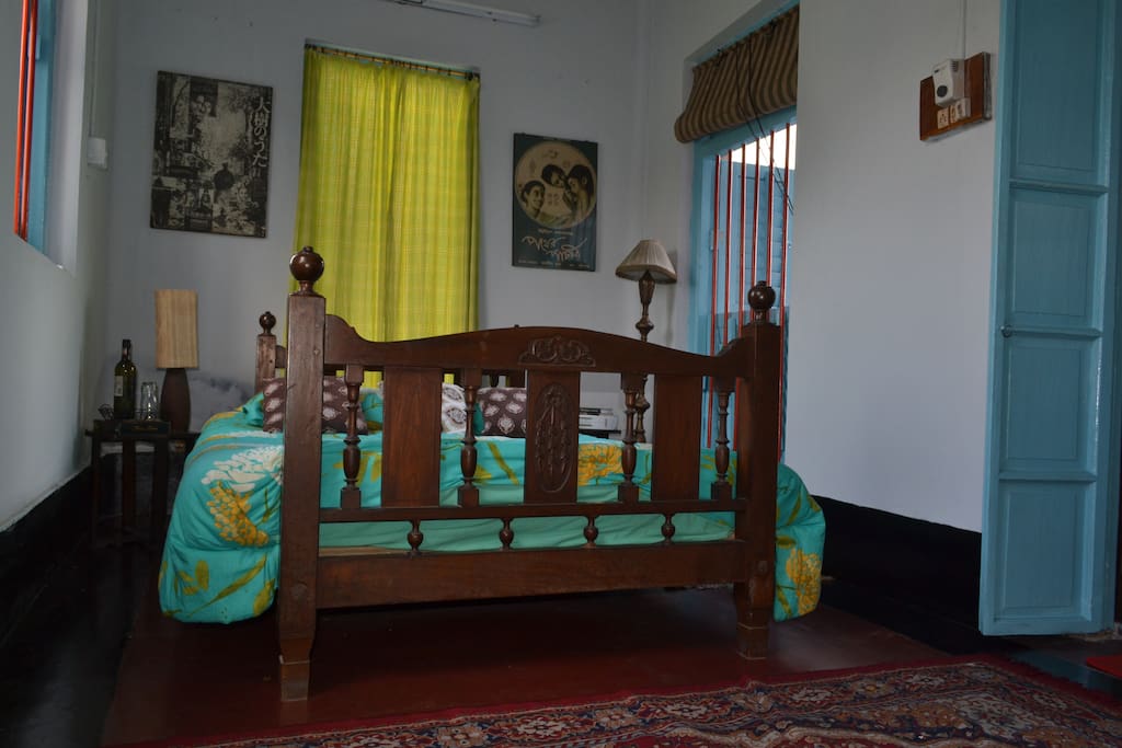 Antique bed with rare Bengali film posters of Satyajit Ray films