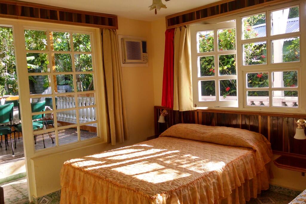 Room with large glass windows and excellent natural lighting looking over the delightful garden and terrace.