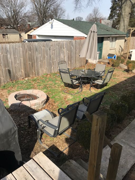 Fenced backyard with fire pit and grill