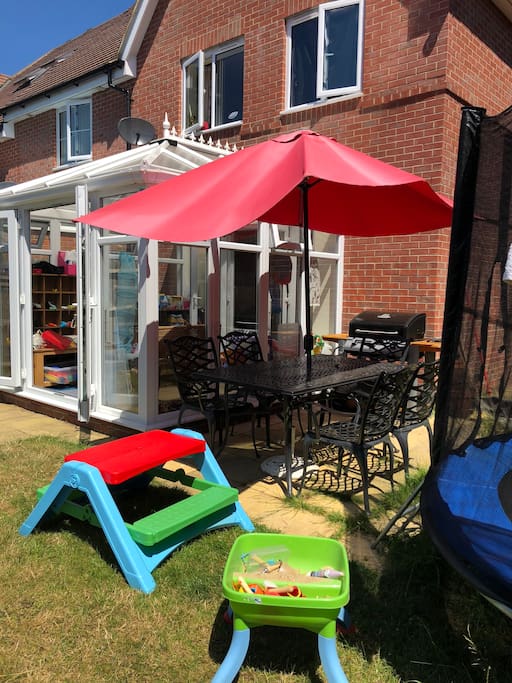 Back of house: Garden with gas BBQ, table & chairs for adults, picnic table for kids, swing, trampoline, dolls house & sand table
