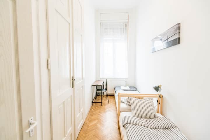 חדר השינה באמצע עם שתי מיטות יחיד ושולחן