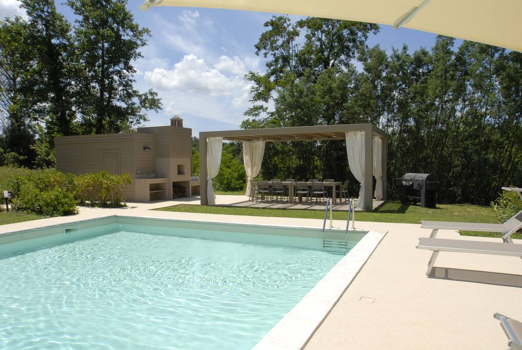Vista piscina con forno, doccia e barbecue