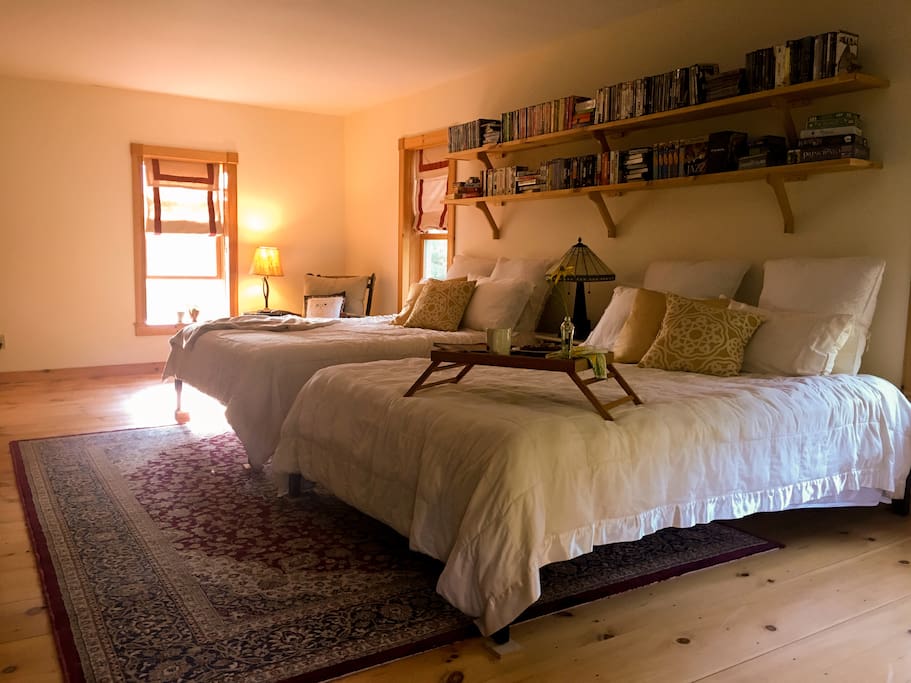 Main guest room has two queen size beds that are accompanied by comfy chairs.