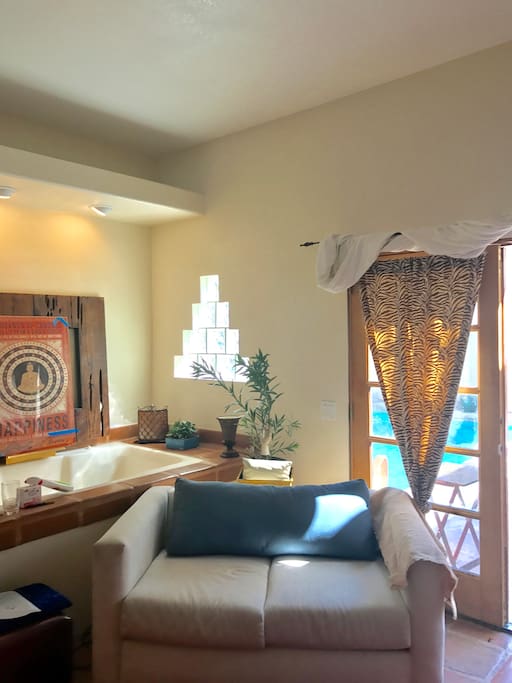 Sitting area with jacuzzi tub in back ground and view of pool out side your door