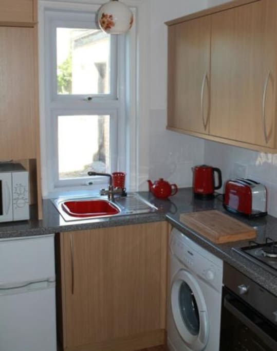 Fully equipped kitchen area with washing machine