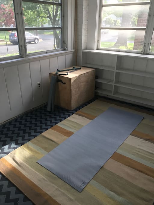 A front sun porch with yoga mats and equipment for stretching in the sun!