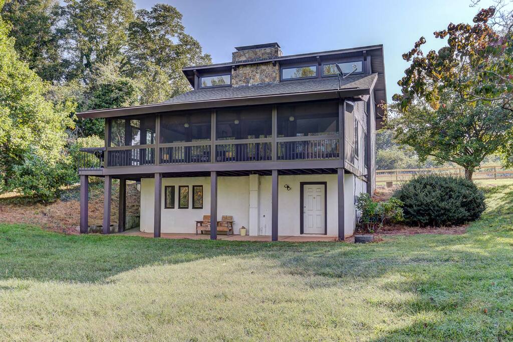 Backside of house with screened-in porch and walk-out basement with covered patio.