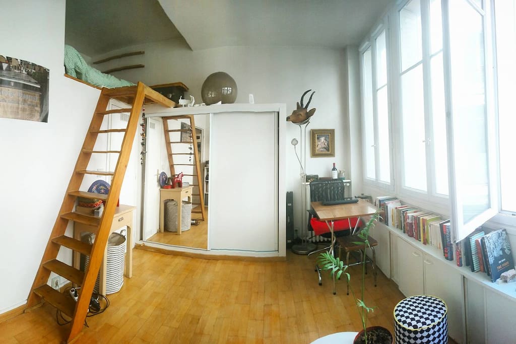 Espace de travail/sale à manger, des chaise supplémentaires pliantes en bois se trouvent sous le sofa. La sale de bain se trouve sous la mezzanine.