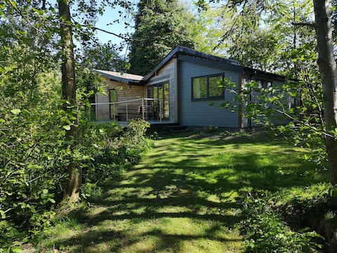 Mouse House set on the edge of a lake in Mid Wales