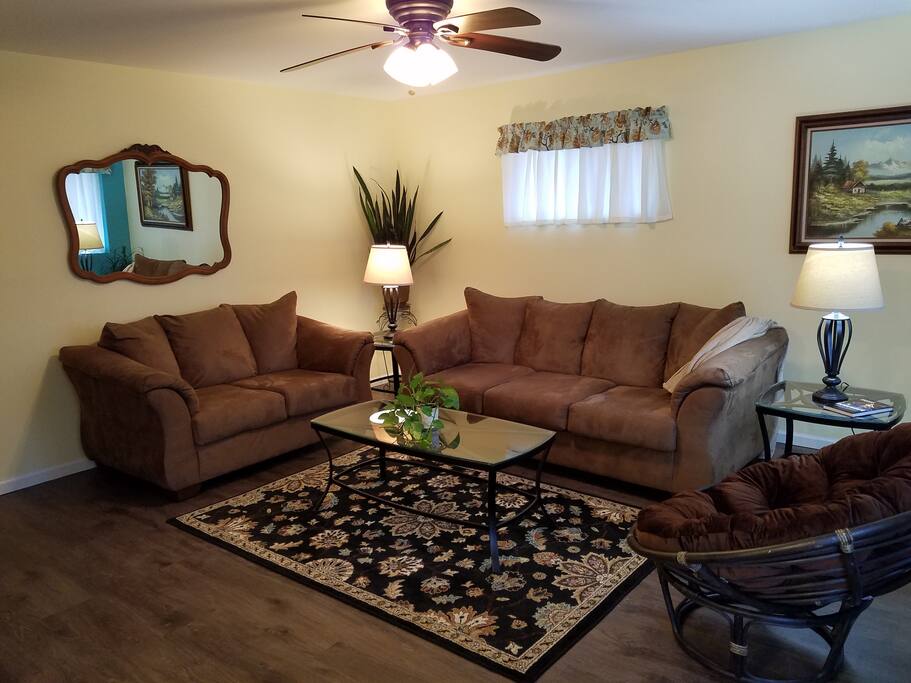 The living room opens into the dining room and kitchen. A hallway to the left leads to the bedrooms and baths.
