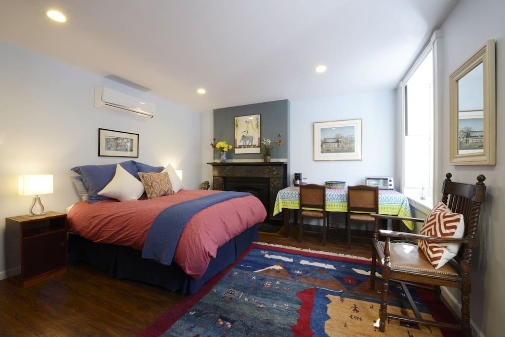 Bedroom has comfy Queen bed w/ Cuddledown sheets, dining table, historic details.