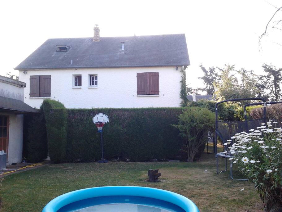 Agréable jardin ensoleillé avec terrasse abritée et barbecue en pierre