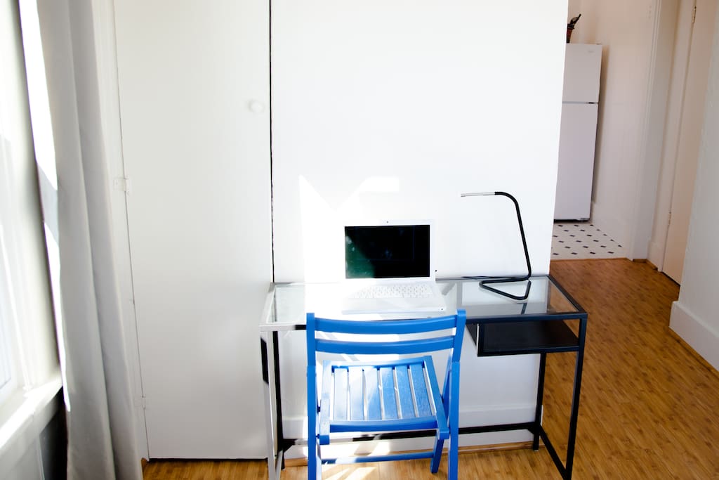 Work space features a sleek and minimal laptop table and LED desk lamp.