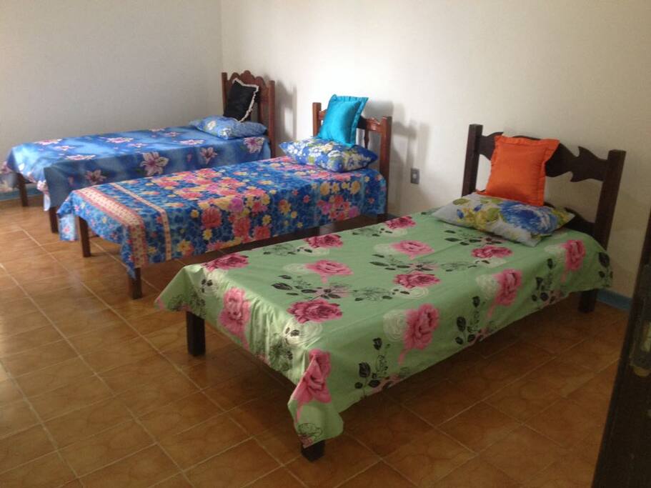Quarto com três camas de solteiro