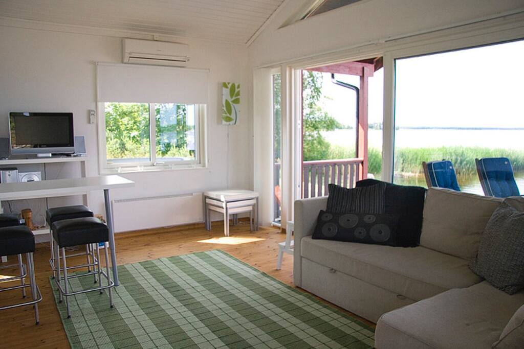 Wake up and hear the waves. Living room with a bed sofa. Table for 4 on the terrace.
