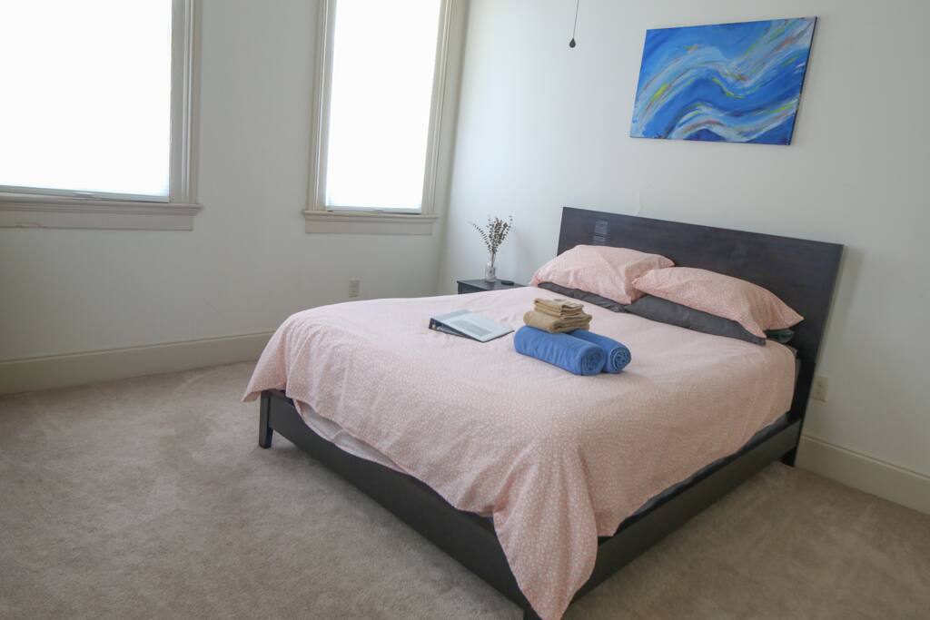 Spacious and comfortable bedroom with dresser, closet, and full-length mirror.