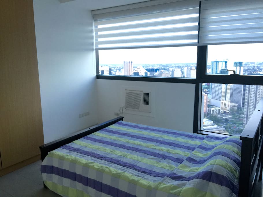Separate bedroom with queen size bed with a view overlooking Ortigas CBD