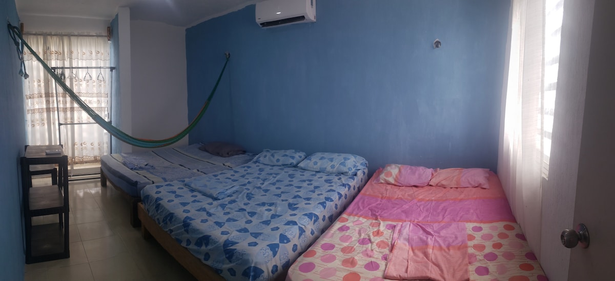 Habitación principal en el segundo piso con balcón, aire acondicionado, 3 camas matrimoniales y 1 hamaca