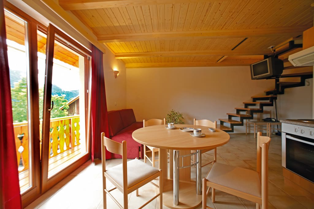 Living area with kitchen and doors on balcony