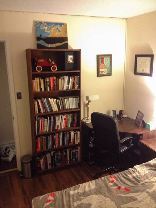 Bedroom includes a corner desk and writing lamp