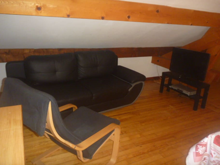 Le coin salon, avec le canapé 3 personnes, le fauteuil, la télévision à écran plat et le lecteur DVD