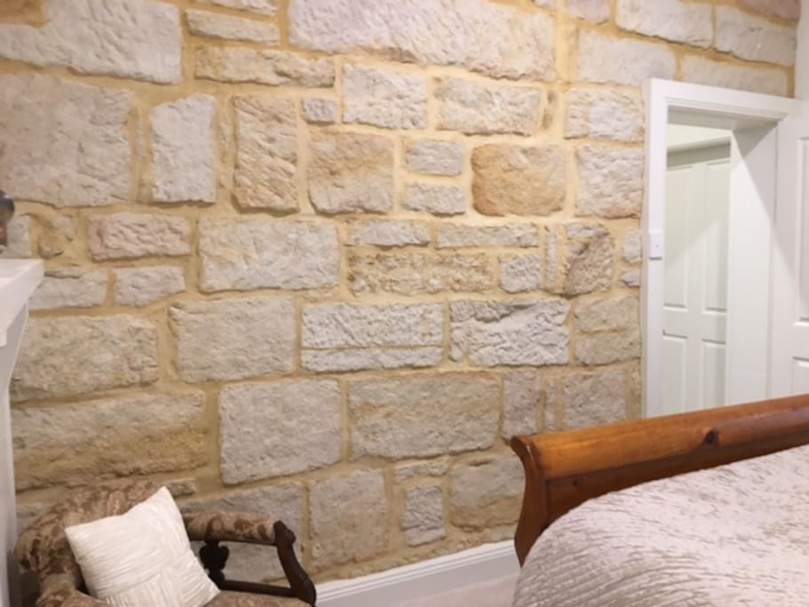 Queen bedroom with featured sand stone wall.