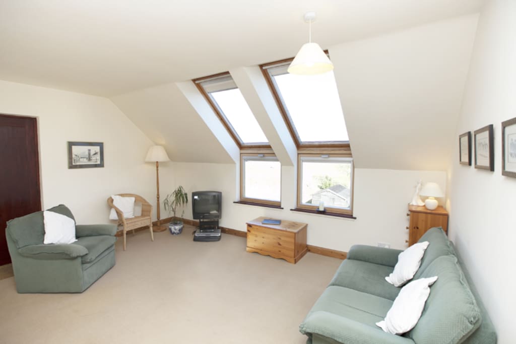 Living area with windows overlooking rear garden and river estuary